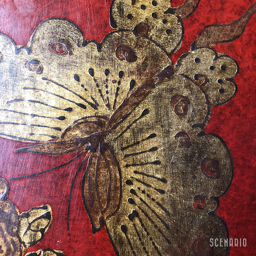 dettaglio-decoro-farfalla-mobile-cinese-shanxi.jpg Dettaglio ravvicinato della decorazione dipinta a mano raffigurante una farfalla dorata su fondo di lacca rossa, Mobile Cinese Shanxi.