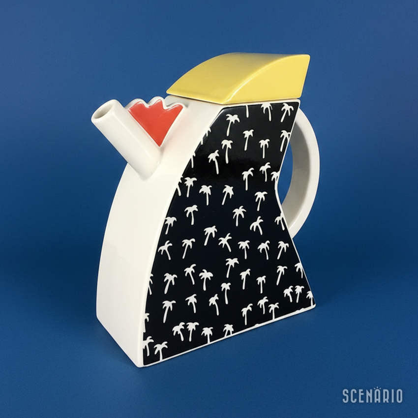 caffettiera-design-anni-80-postmoderno-vista-destra.jpg Vista di 3/4 del lato destro della caffettiera d'epoca in stile Memphis. Questa angolazione evidenzia la forma irregolare della base bianca, il beccuccio tubolare con il dettaglio arancio e il coperchio giallo.