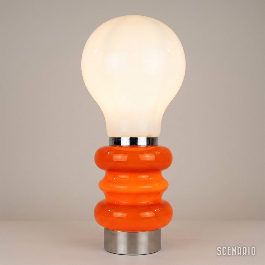 lampada-nason-mazzega-bulbo-arancio-accesa.jpg Lampada vintage Carlo Nason per AV Mazzega accesa con base in vetro arancione e diffusore bianco a forma di bulbo.